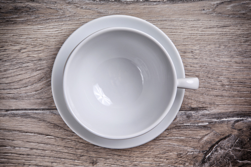 White porcelain cup with saucer on a wooden background